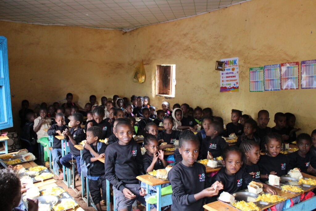 Children in a school classroom enjoying lunch, supporting education and nutrition in Ethiopia.